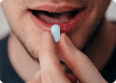 Homme prenant une gélule avec un verre d'eau